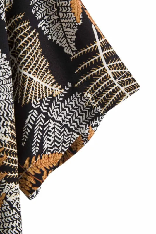 Camisa Manga Curta Marcanzzi Marbella MZ581 com estampa tropical de folhas em preto, branco e dourado, tecido leve, caimento confortável e versátil.